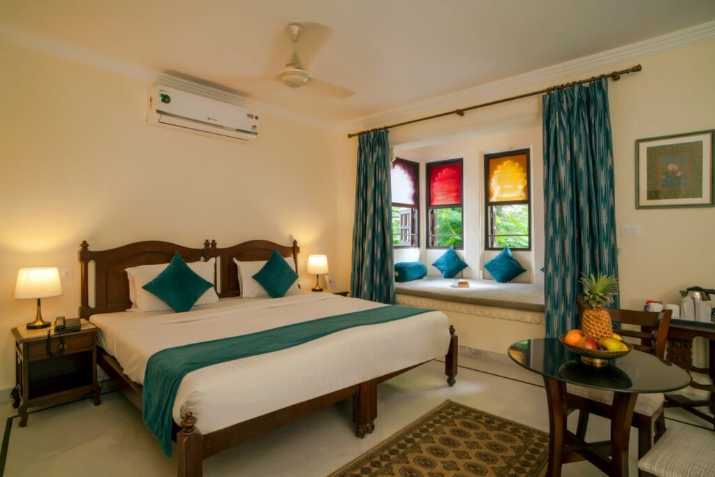 Elegant hotel room featuring a comfortable bed, window nook, and stylish decor.