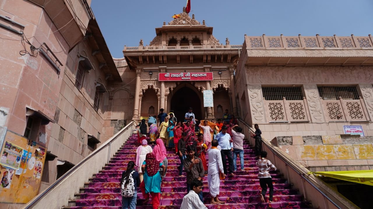 Pilgrims walking up the vibrant stairs of Shri Radha Rani Temple in Barsana, India.